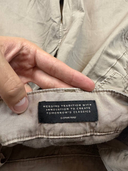 G-Star Raw beige cotton trousers with flap pockets and branded metal button closure.
