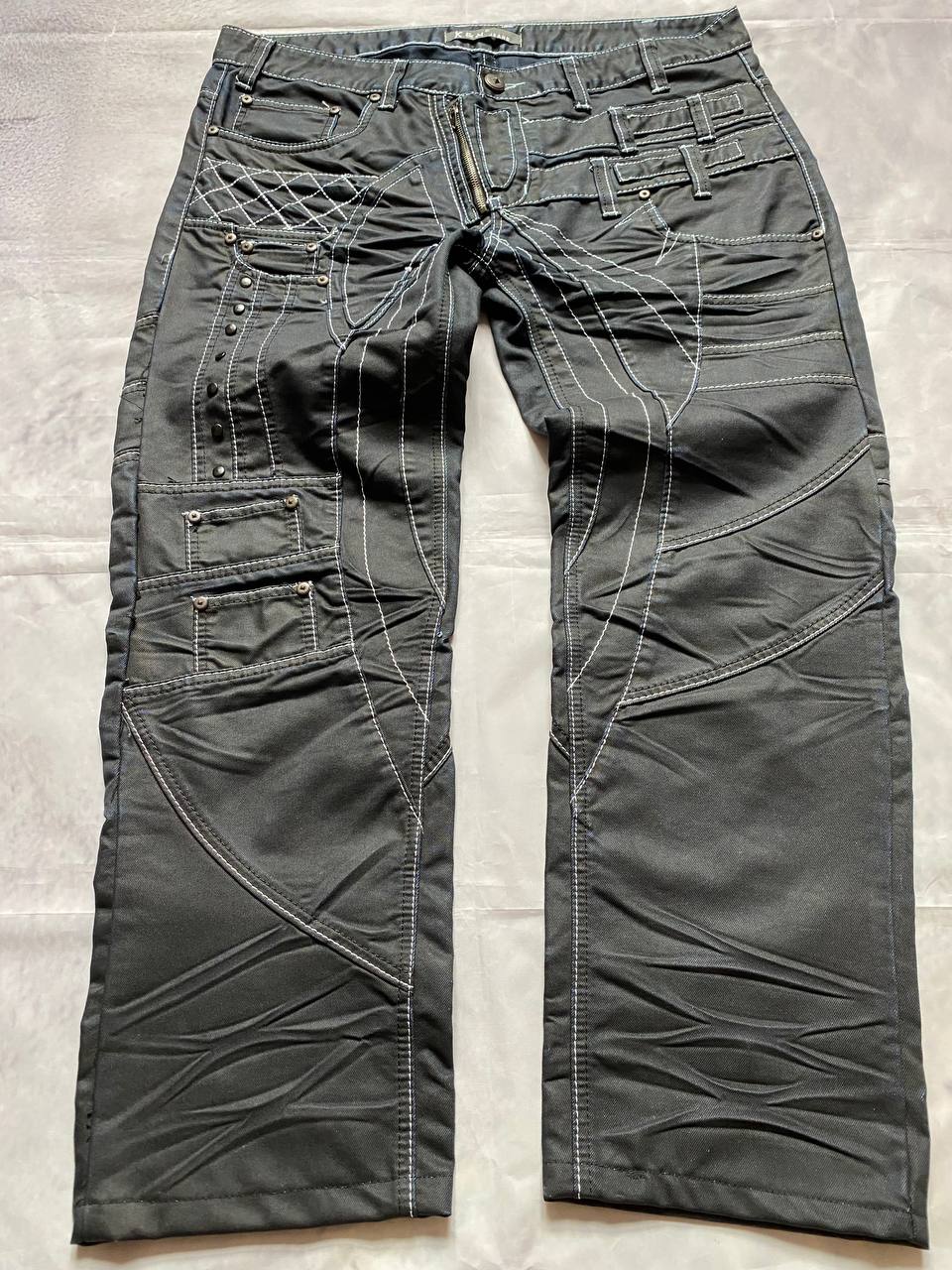 K&M black jeans size 38 with detailed white stitching and metallic stud accents.