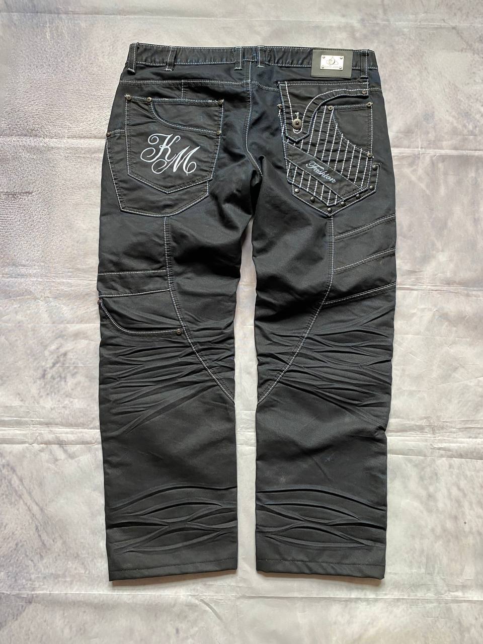 K&M black jeans size 38 with detailed white stitching and metallic stud accents.