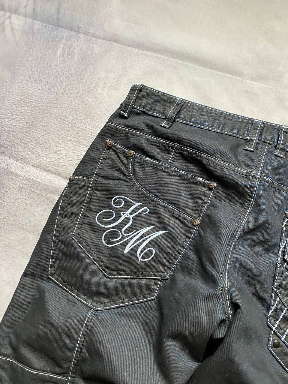 K&M black jeans size 38 with detailed white stitching and metallic stud accents.