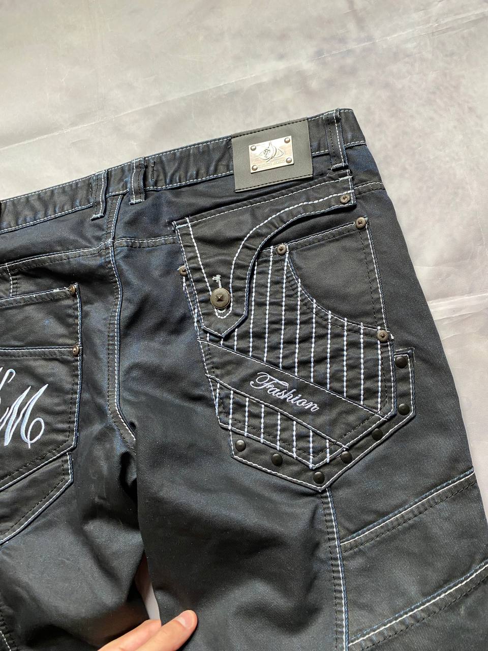 K&M black jeans size 38 with detailed white stitching and metallic stud accents.
