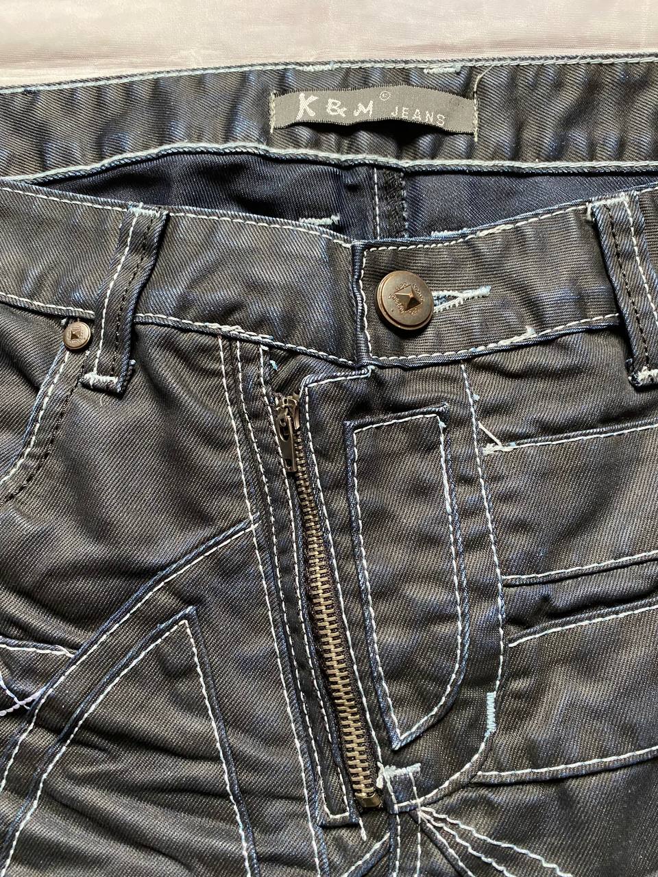 K&M black jeans size 38 with detailed white stitching and metallic stud accents.
