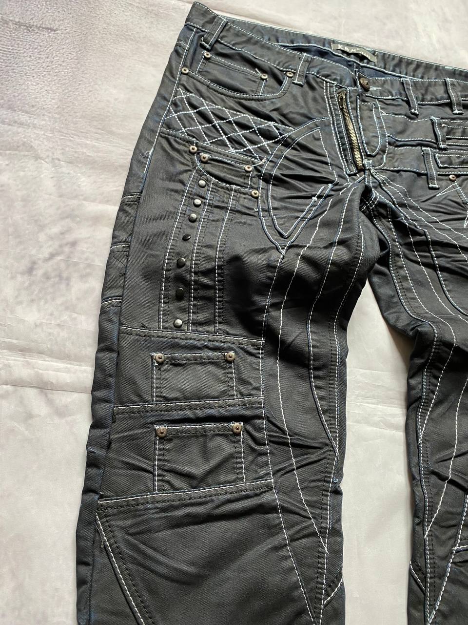K&M black jeans size 38 with detailed white stitching and metallic stud accents.