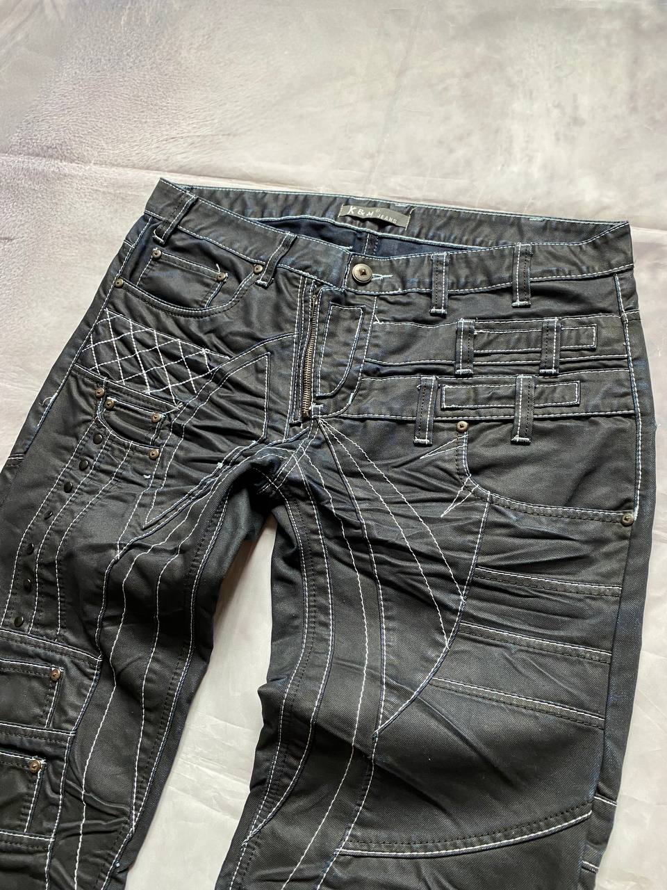 K&M black jeans size 38 with detailed white stitching and metallic stud accents.