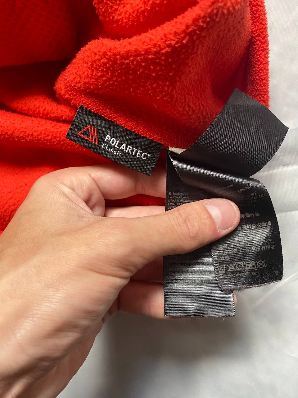 Marmot red fleece jacket with full zip, thumb holes, and elbow patch detail.