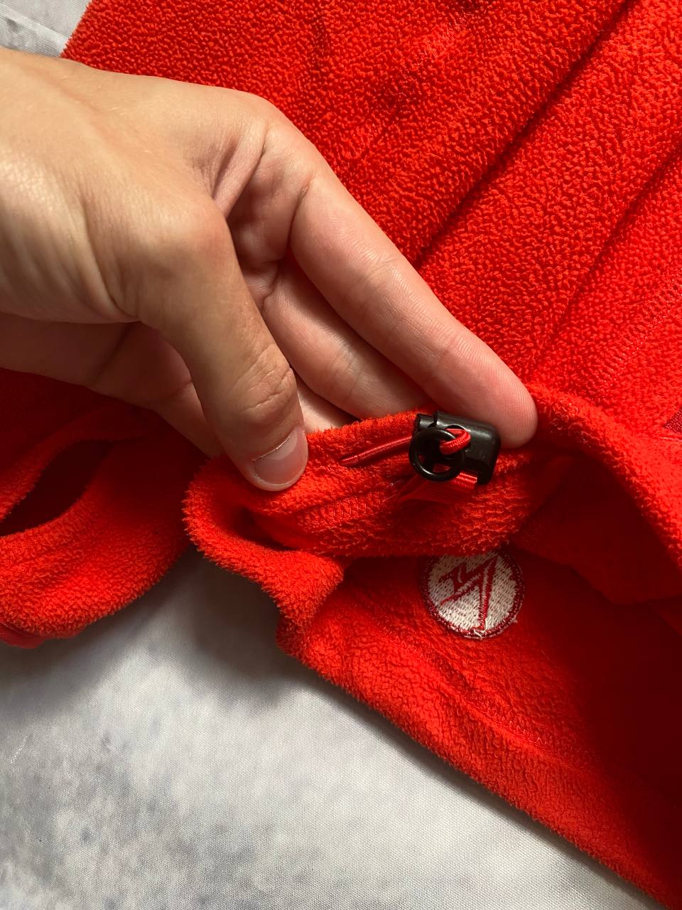 Marmot red fleece jacket with full zip, thumb holes, and elbow patch detail.