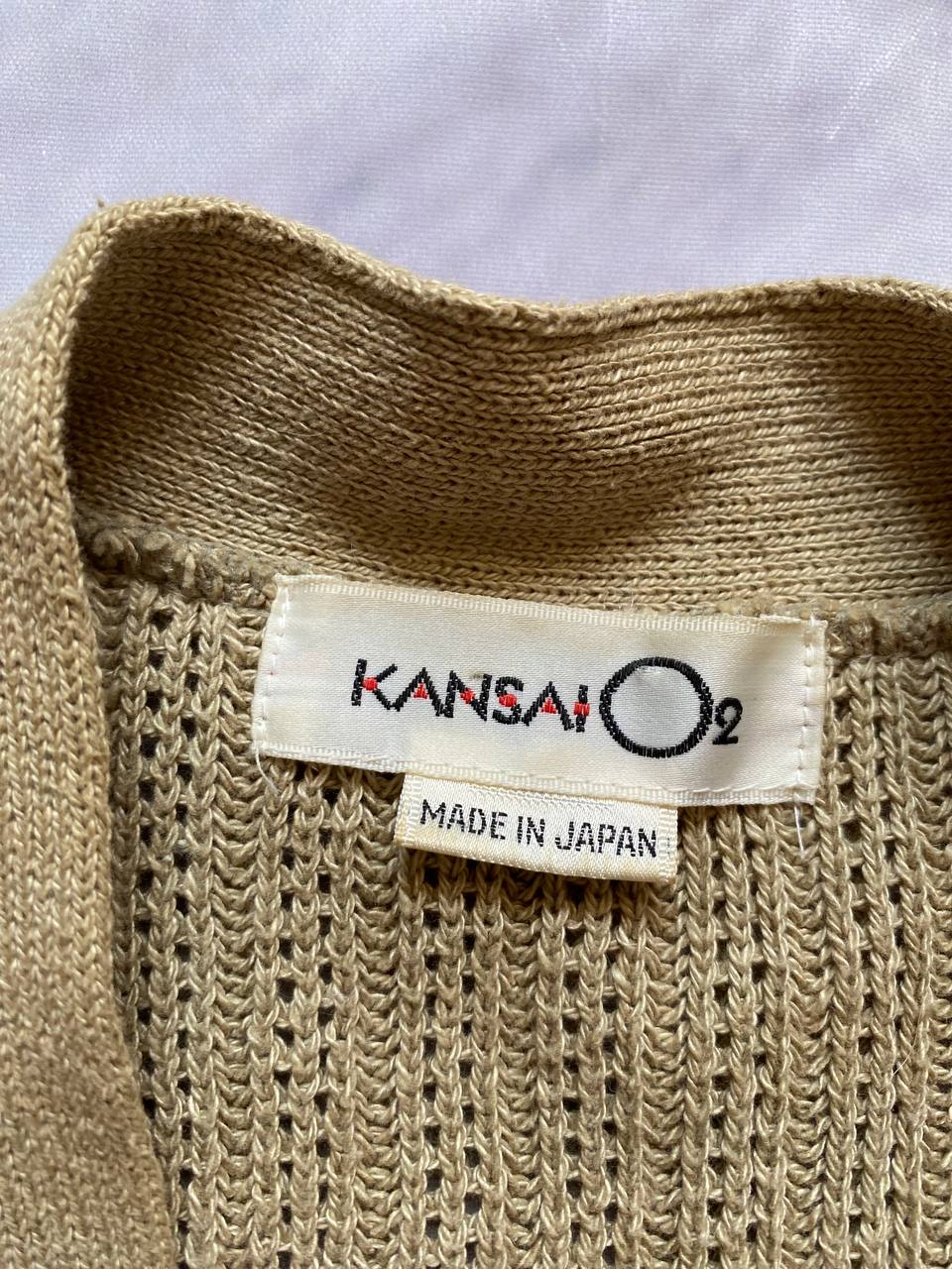 Kansai O2 beige knitted cardigan with embroidered bird detail and fabric patches.
