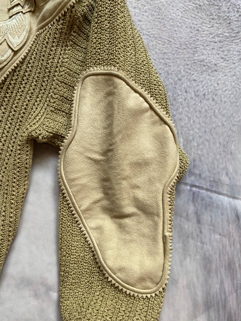 Kansai O2 beige knitted cardigan with embroidered bird detail and fabric patches.