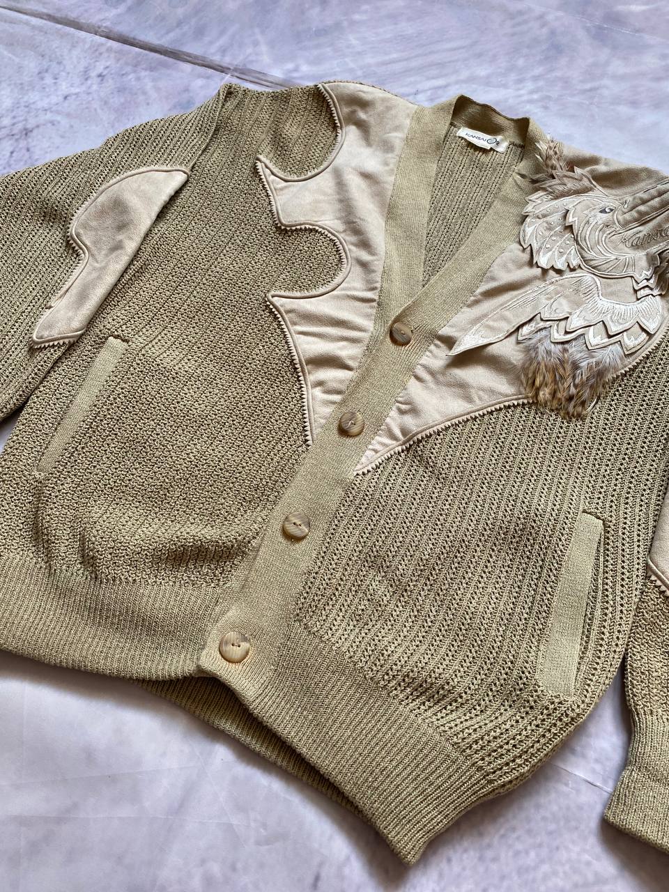 Kansai O2 beige knitted cardigan with embroidered bird detail and fabric patches.