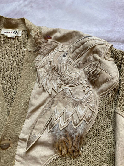 Kansai O2 beige knitted cardigan with embroidered bird detail and fabric patches.
