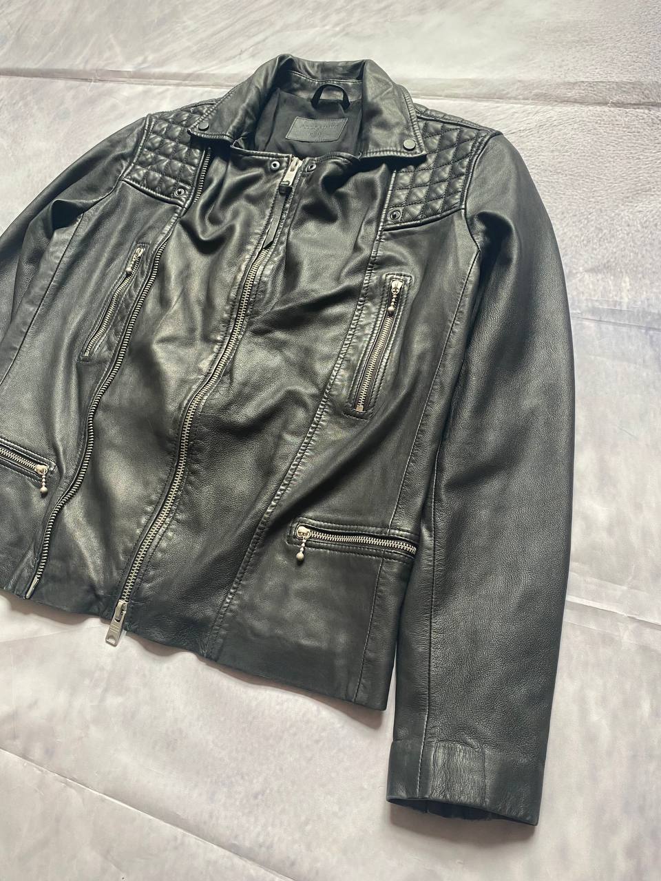 All Saints black quilted leather biker jacket with zippered pockets and adjustable cuffs.