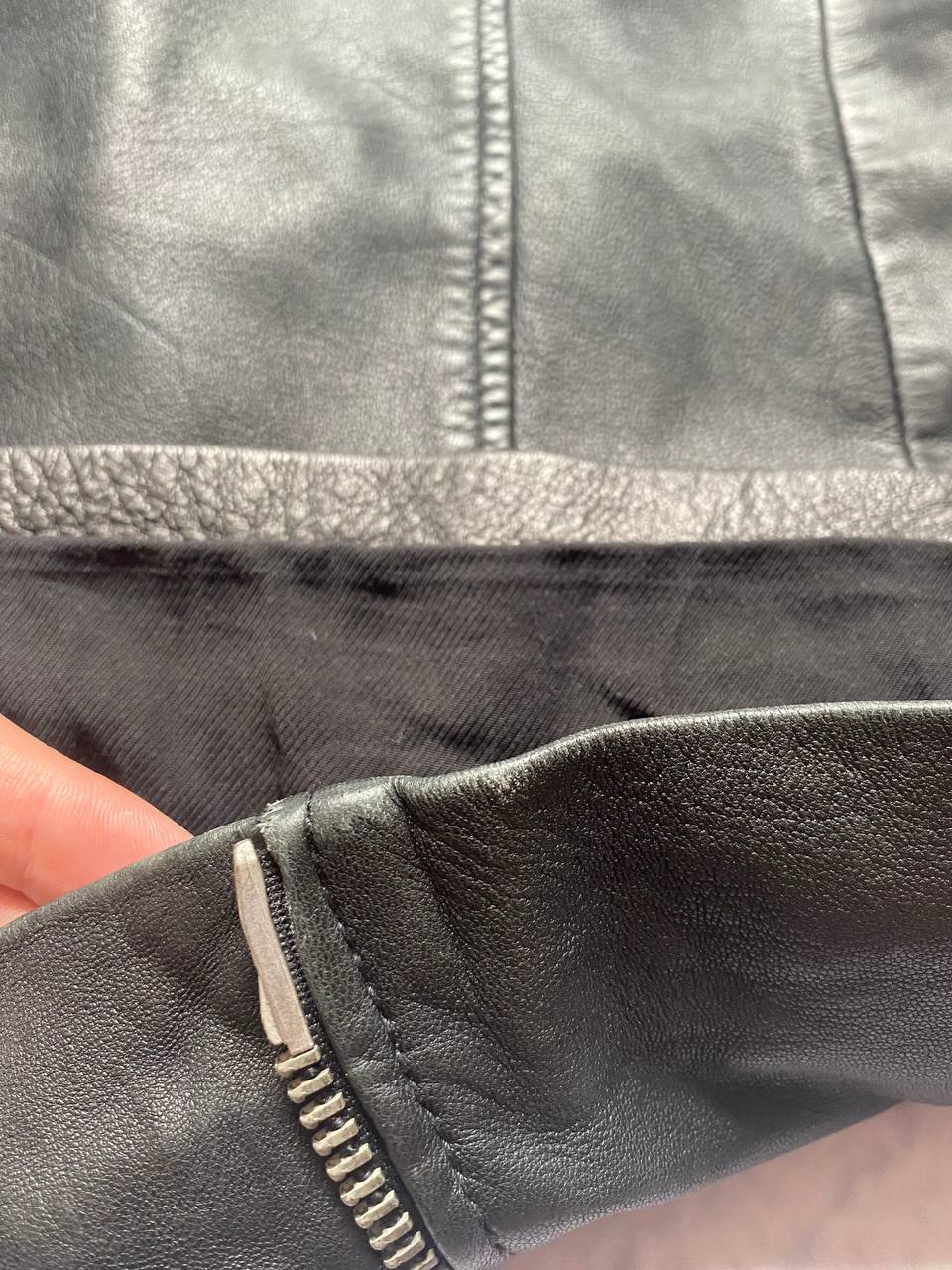 All Saints black quilted leather biker jacket with zippered pockets and adjustable cuffs.