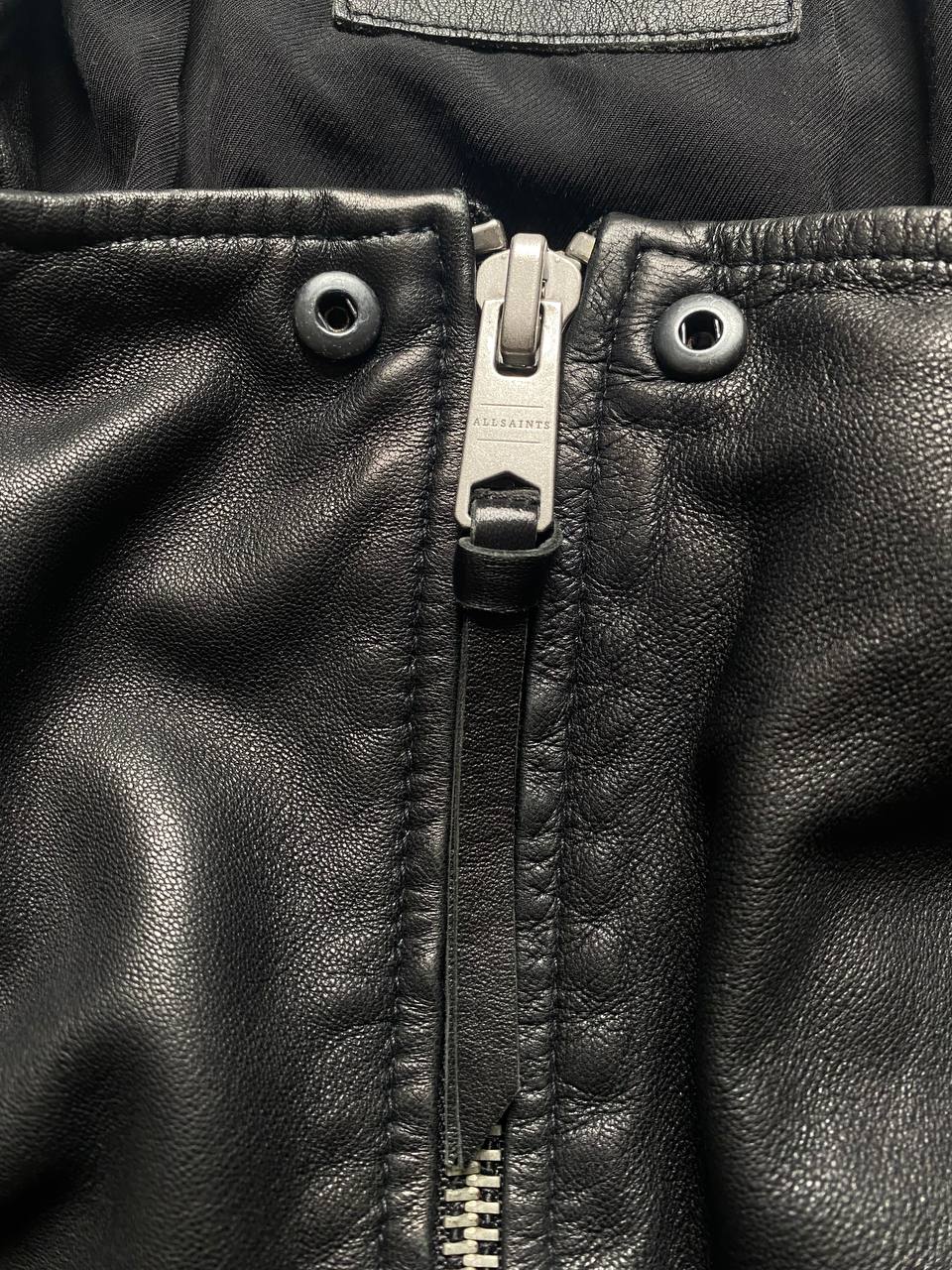 All Saints black quilted leather biker jacket with zippered pockets and adjustable cuffs.