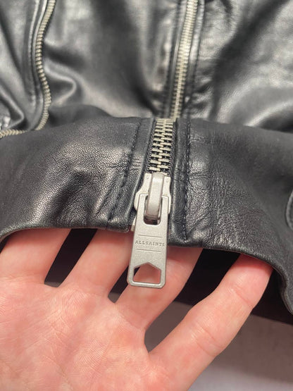 All Saints black quilted leather biker jacket with zippered pockets and adjustable cuffs.