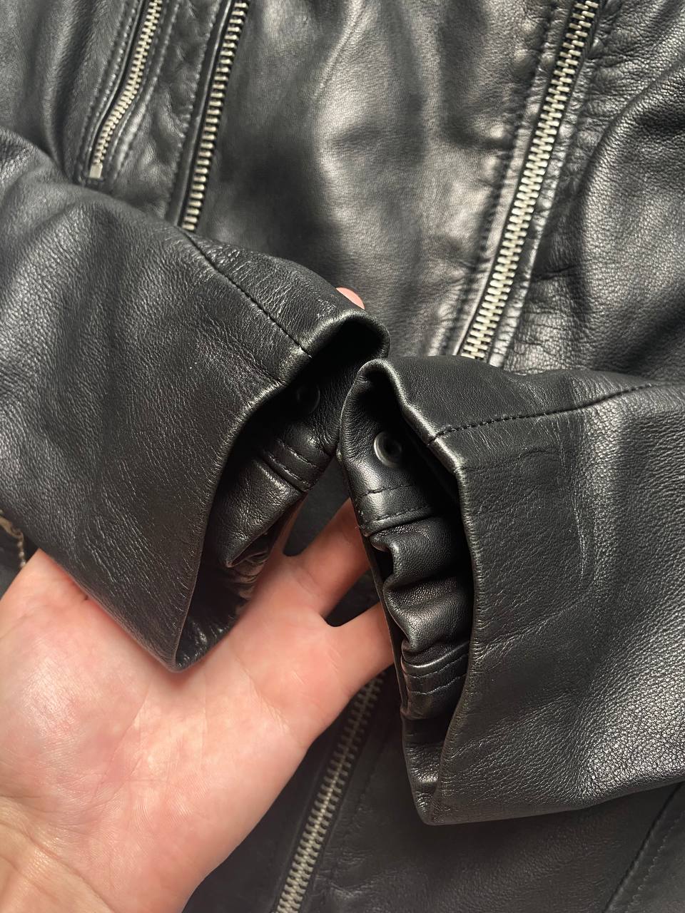 All Saints black quilted leather biker jacket with zippered pockets and adjustable cuffs.