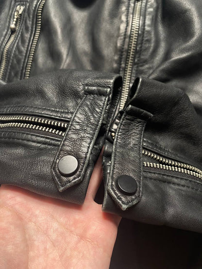 All Saints black quilted leather biker jacket with zippered pockets and adjustable cuffs.
