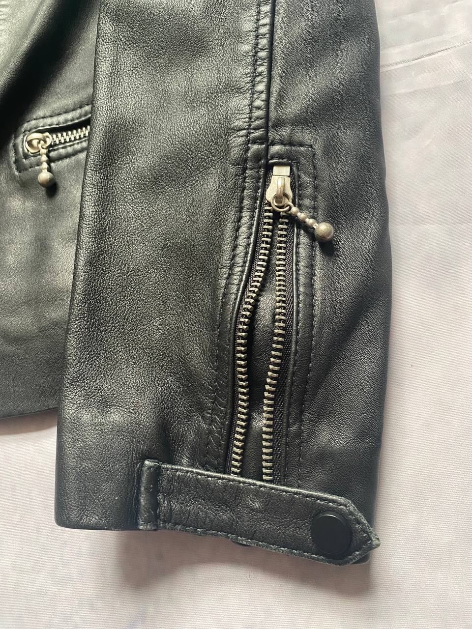 All Saints black quilted leather biker jacket with zippered pockets and adjustable cuffs.