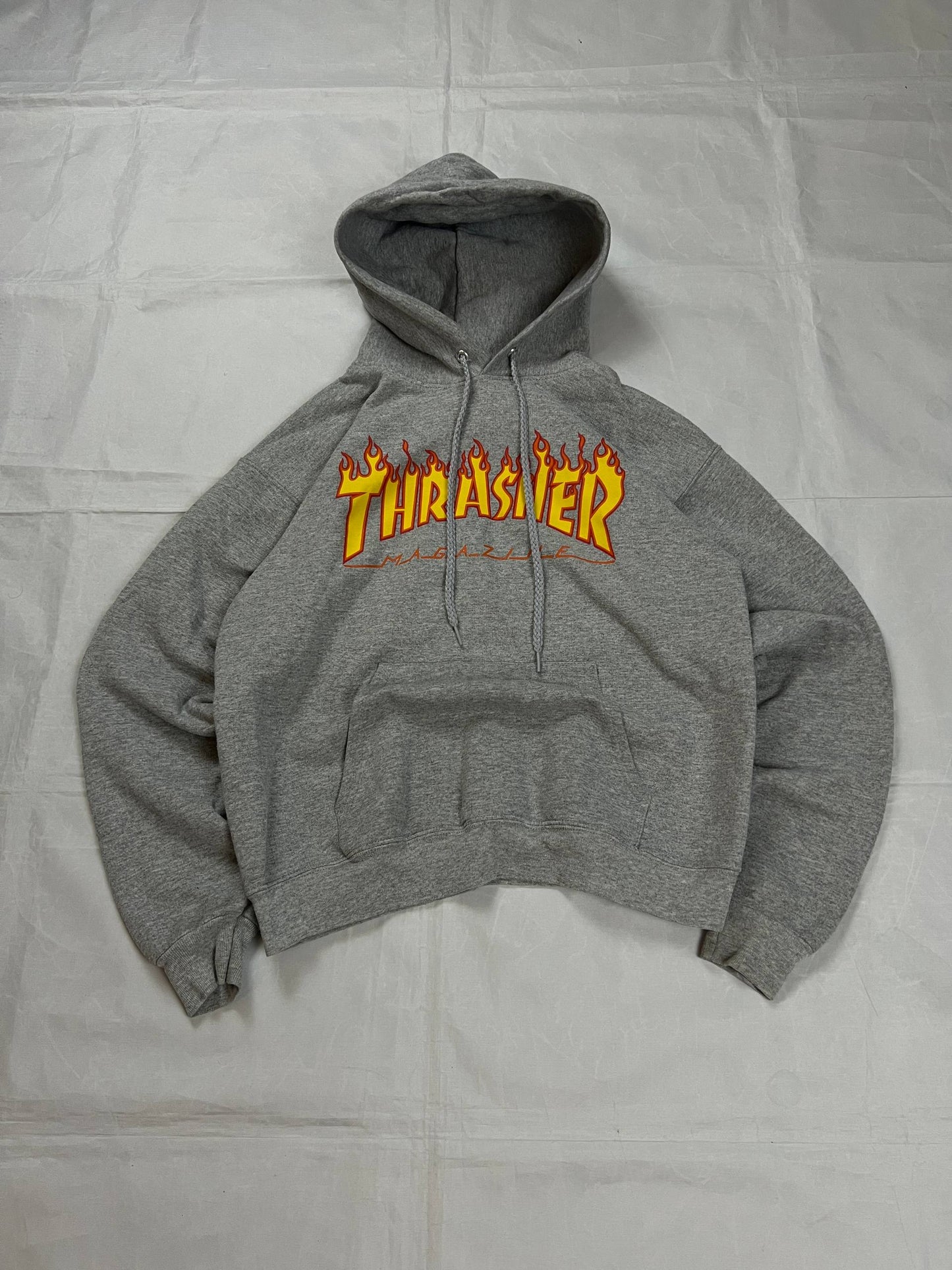 Thrasher grey hoodie with yellow and red flaming logo, kangaroo pocket, drawstring hood.