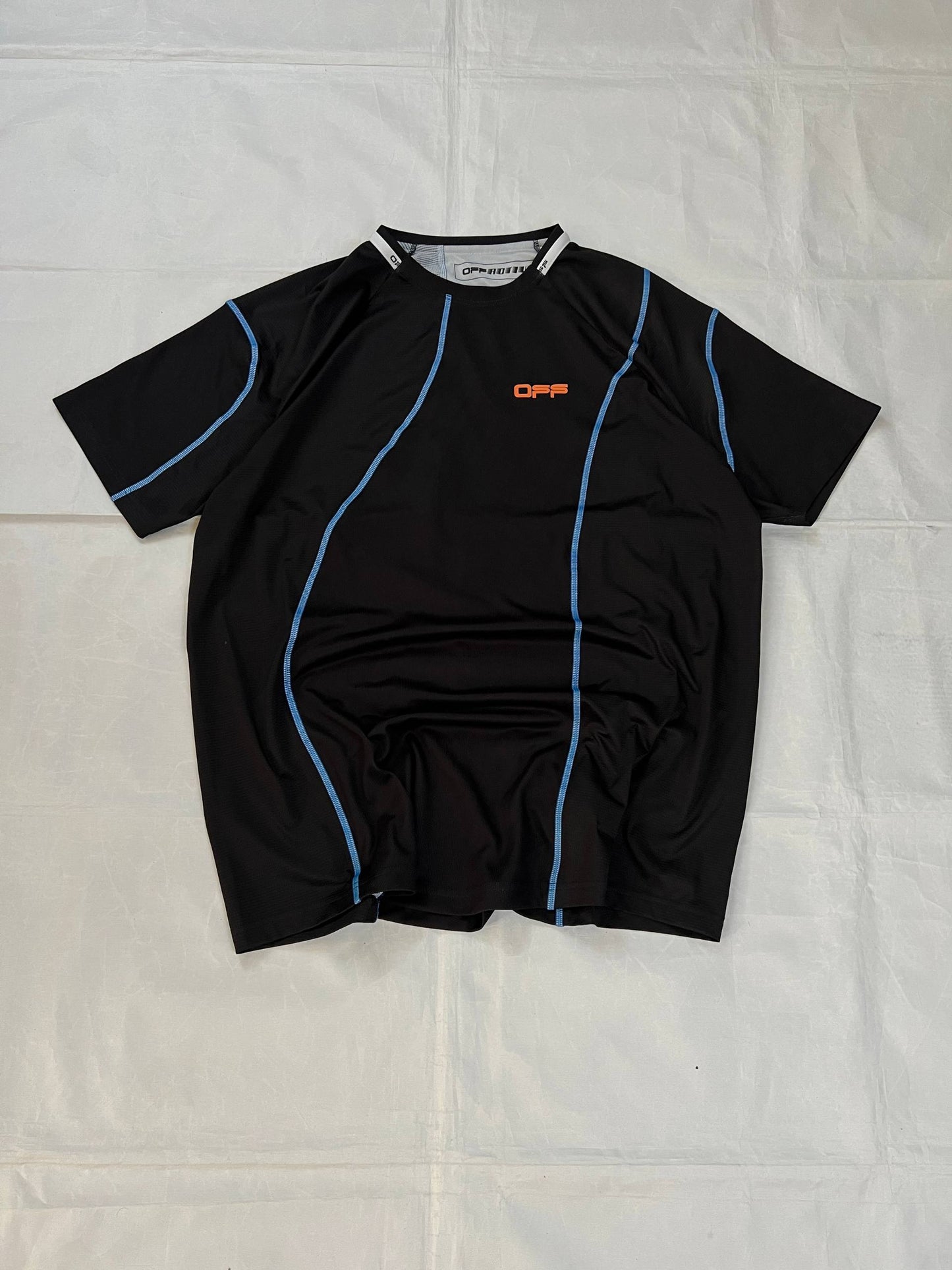 OFF black technical t-shirt with blue stitching and orange logo accents.