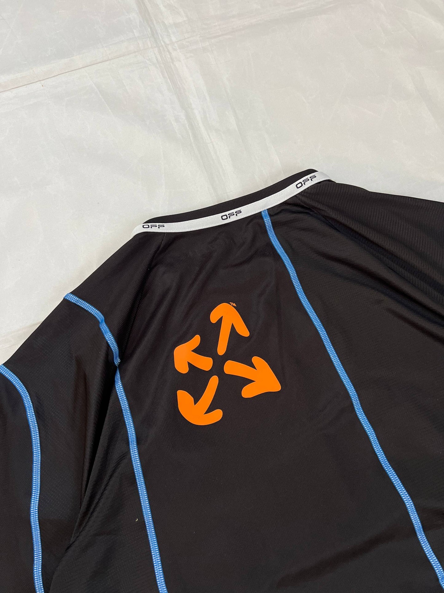 OFF black technical t-shirt with blue stitching and orange logo accents.