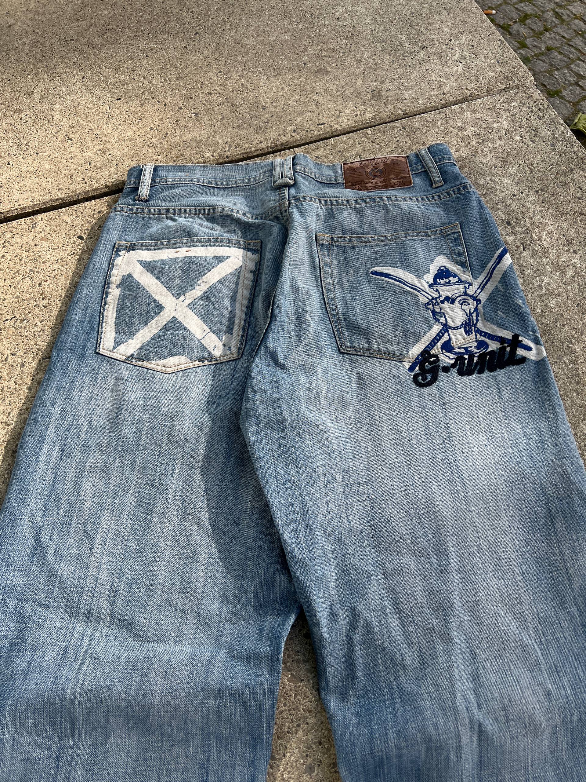G-Unit light blue denim jeans with unique back pocket designs and leather brand patch.