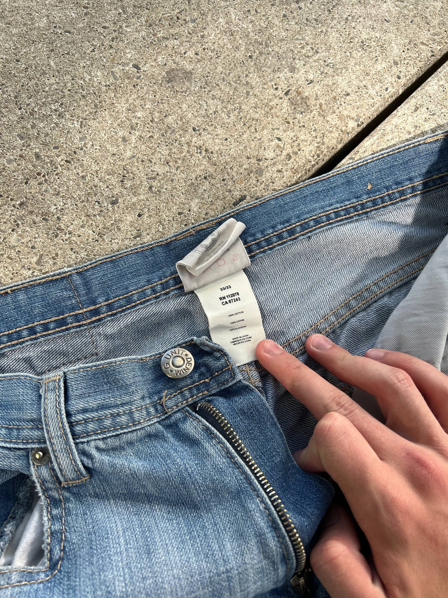 G-Unit light blue denim jeans with unique back pocket designs and leather brand patch.