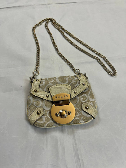 Guess beige mini crossbody bag with white signature print and gold-tone chain strap.