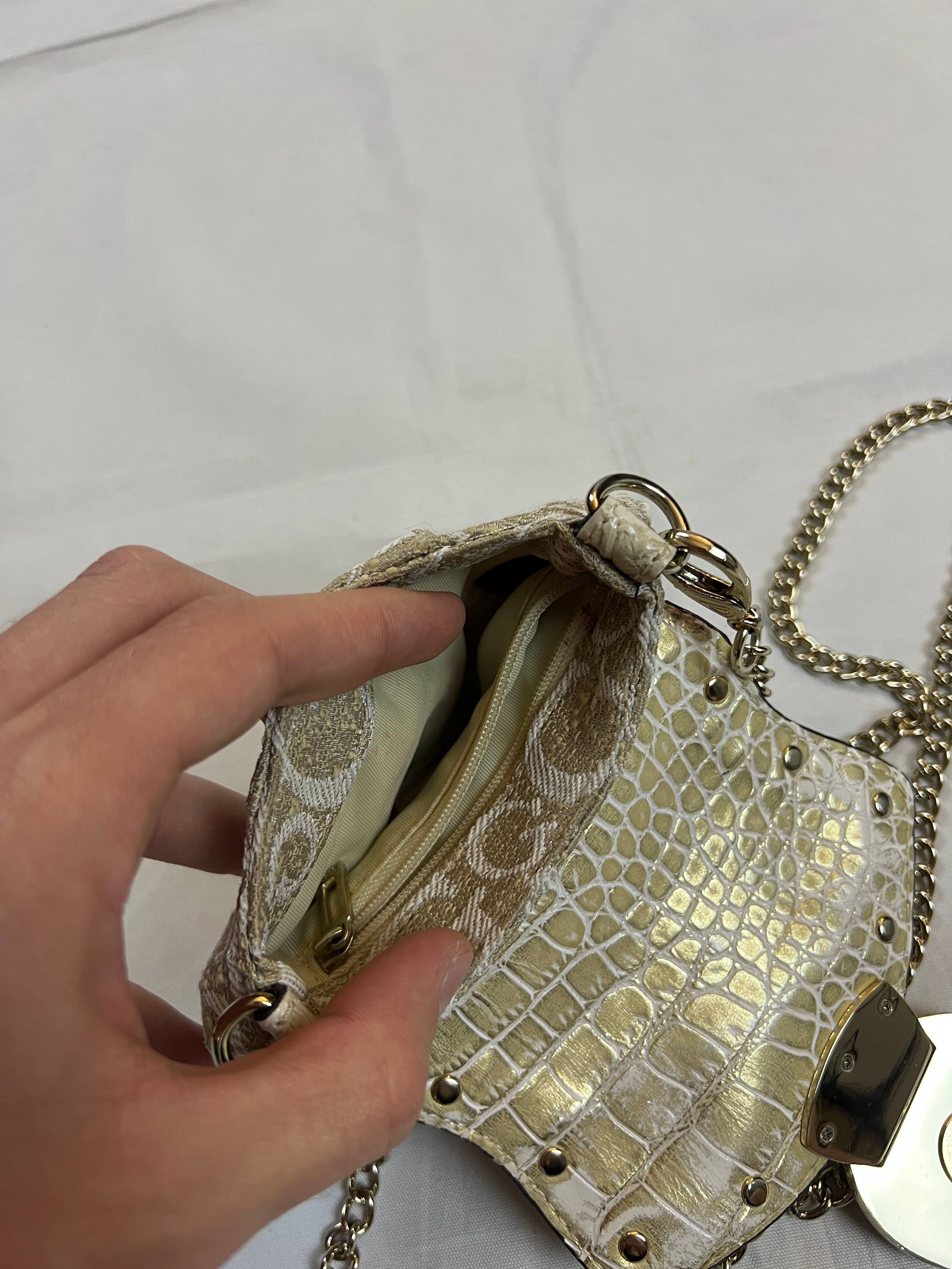 Guess beige mini crossbody bag with white signature print and gold-tone chain strap.