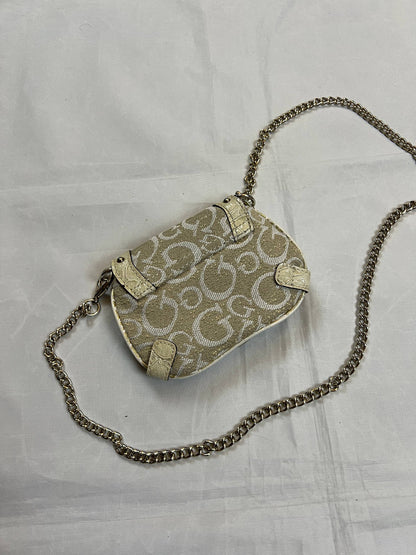 Guess beige mini crossbody bag with white signature print and gold-tone chain strap.