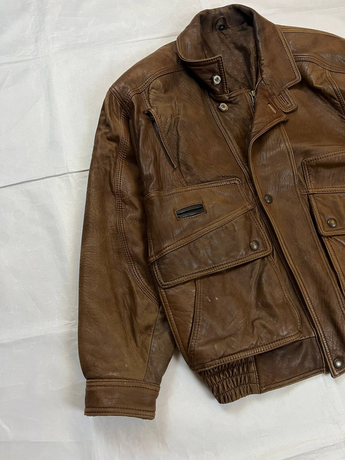 Bomber brown leather men's vintage bomber jacket with elasticized waist and flap pockets.