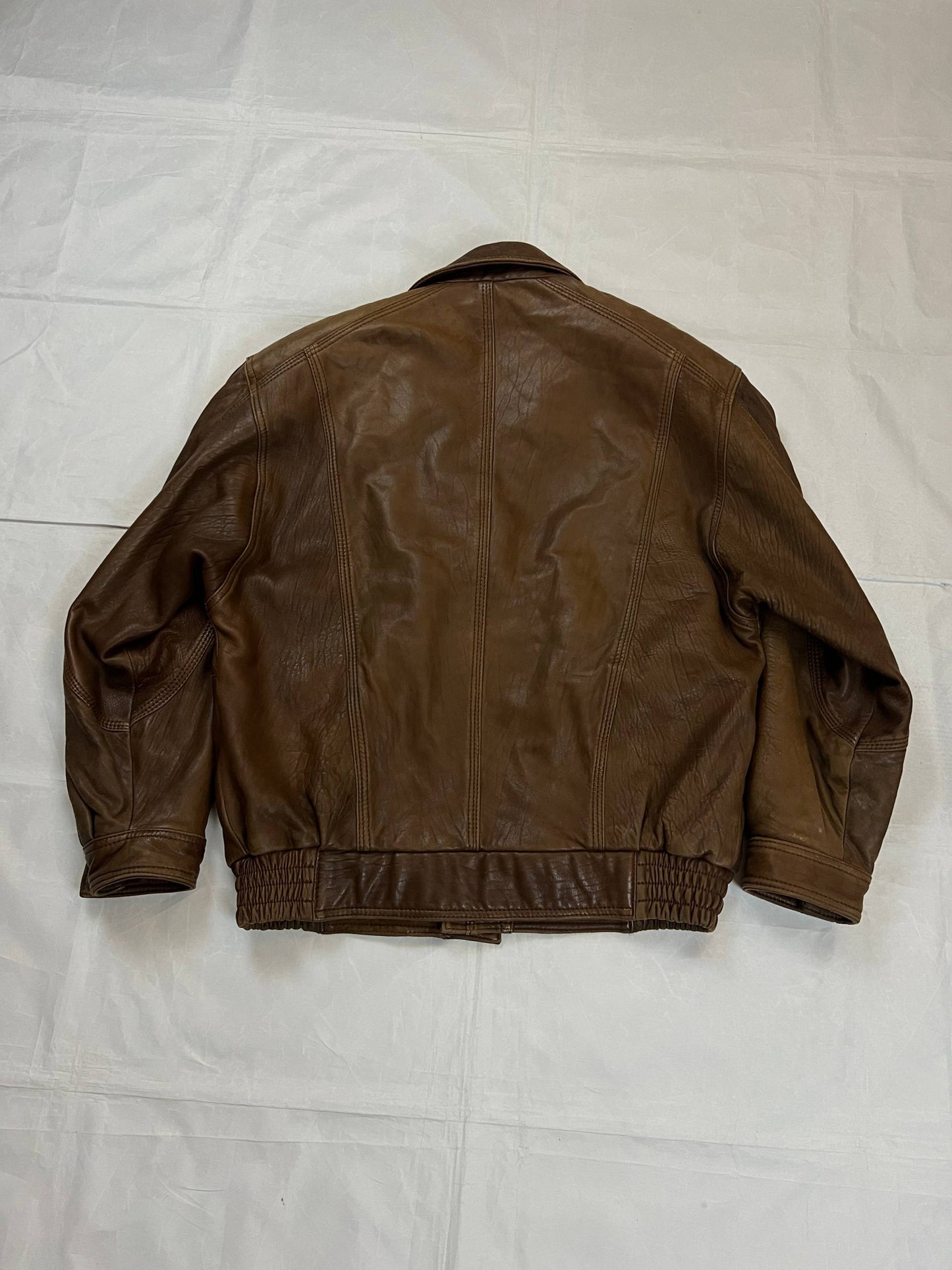 Bomber brown leather men's vintage bomber jacket with elasticized waist and flap pockets.