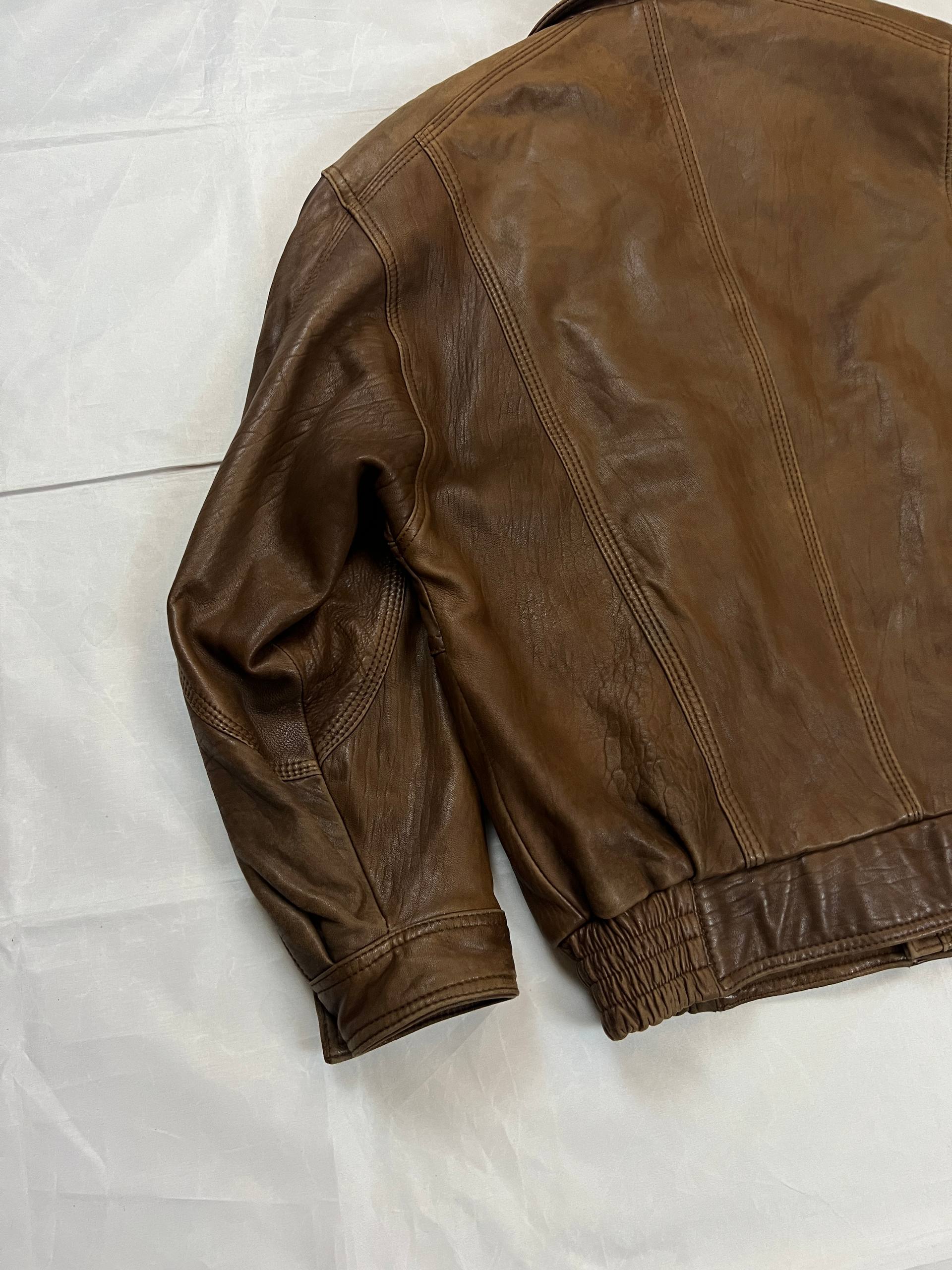 Bomber brown leather men's vintage bomber jacket with elasticized waist and flap pockets.