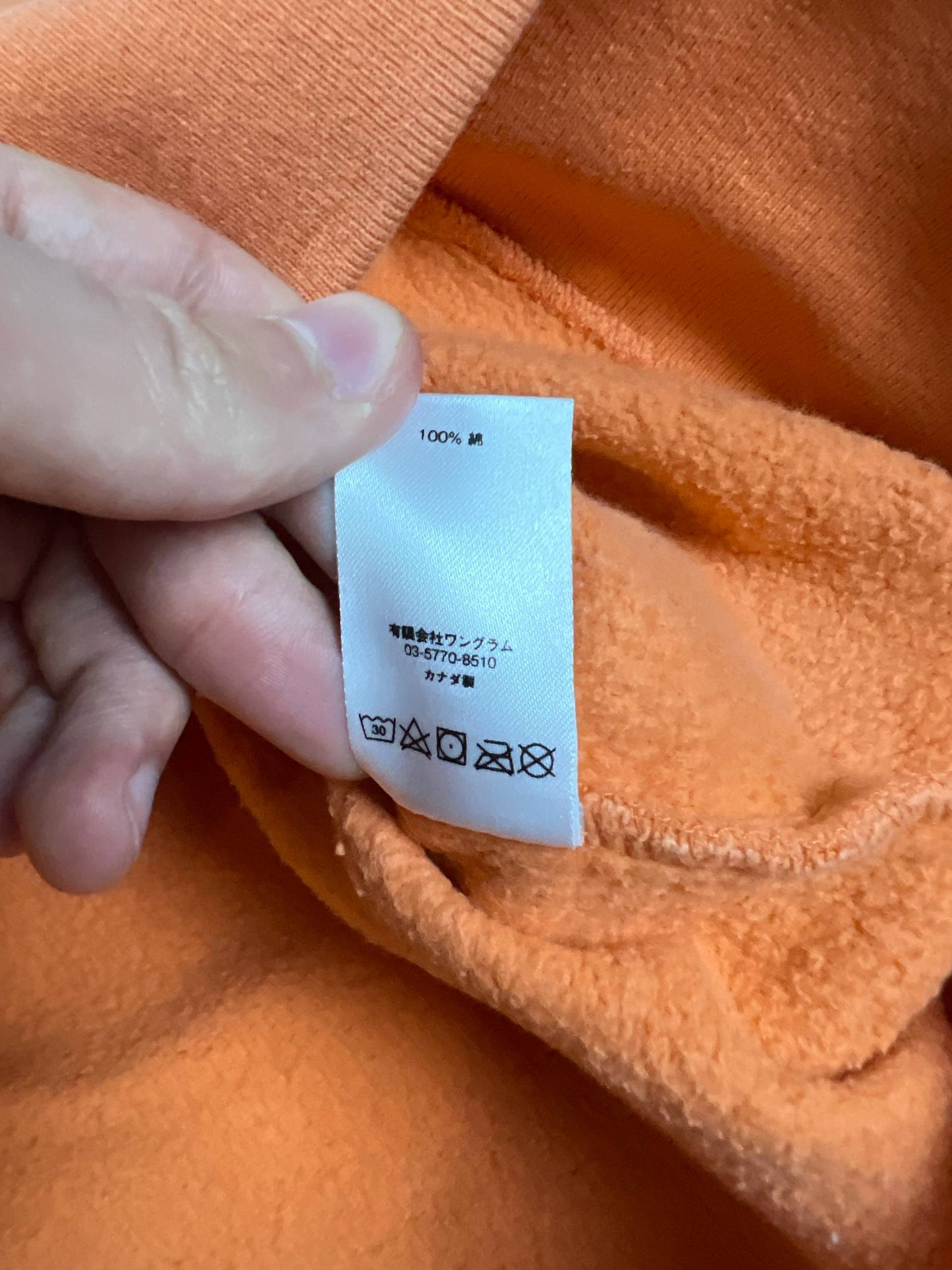 Supreme orange crewneck sweatshirt large embroidered logo on chest, soft cotton material.
